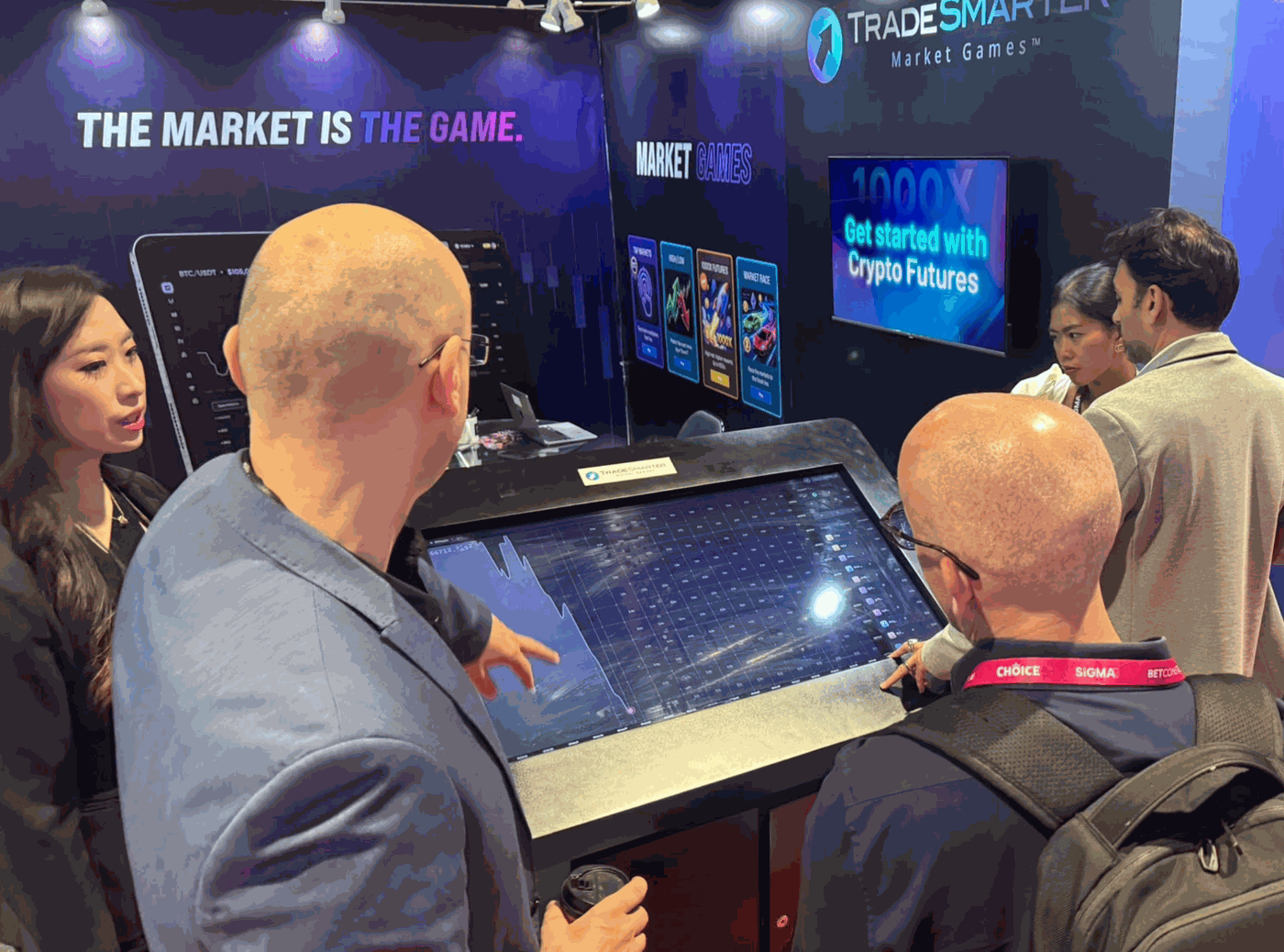Operators trying the Tap Markets™ touch-table demo at the Tradesmarter booth, SiGMA Asia 2026